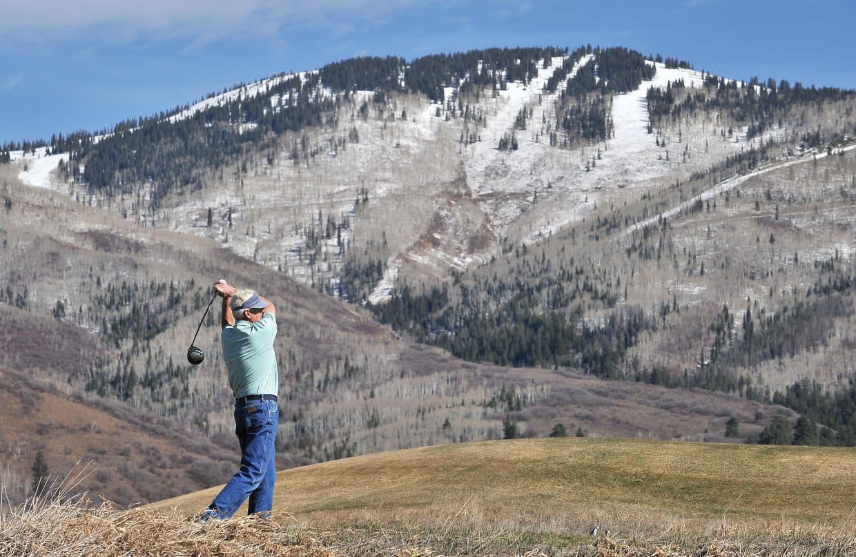 Bob Conroy, founder of Conroy Moving & Storage, golfing with Steamboat ski mountain in the background